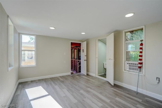 unfurnished bedroom featuring cooling unit and light wood-type flooring