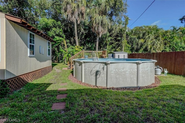 view of swimming pool featuring a lawn and a shed