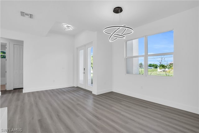 unfurnished living room featuring a chandelier and hardwood / wood-style flooring