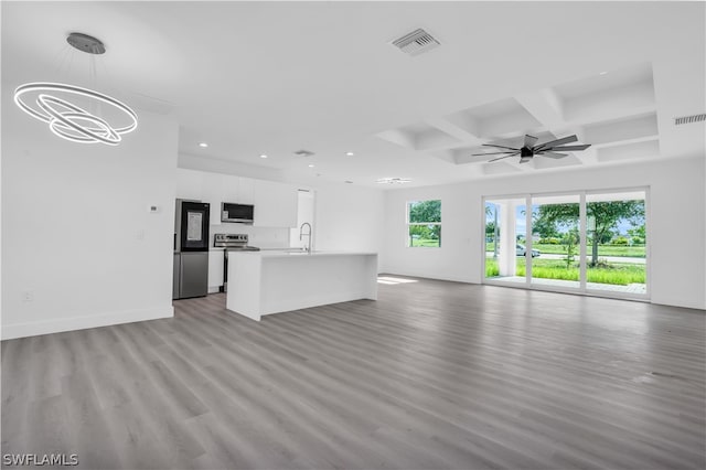 unfurnished living room featuring coffered ceiling, ceiling fan with notable chandelier, sink, light wood-type flooring, and beam ceiling