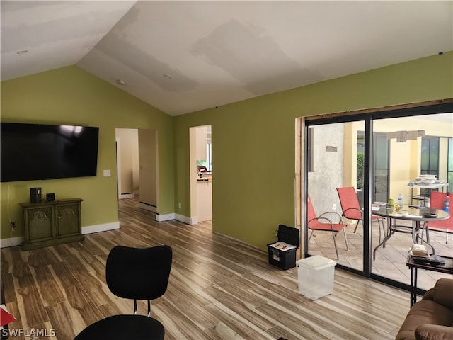 living room with a wealth of natural light, lofted ceiling, and hardwood / wood-style floors