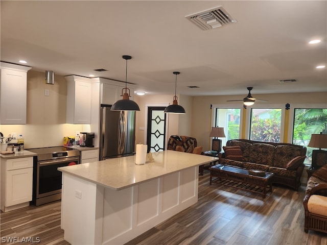 kitchen with hanging light fixtures, dark hardwood / wood-style flooring, white cabinets, and appliances with stainless steel finishes