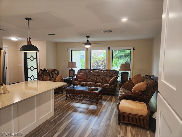 living room featuring dark wood-type flooring and ceiling fan