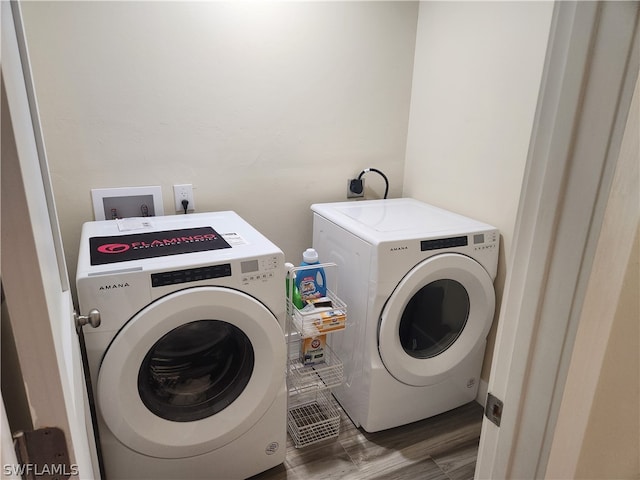 laundry room featuring washer and clothes dryer, wood-type flooring, hookup for a washing machine, and hookup for an electric dryer