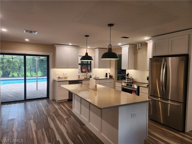 kitchen with dark hardwood / wood-style floors, a center island, stainless steel appliances, and white cabinetry