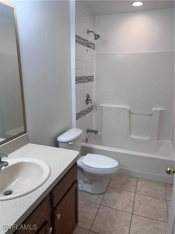 full bathroom with toilet, tile patterned floors, vanity, and tiled shower / bath