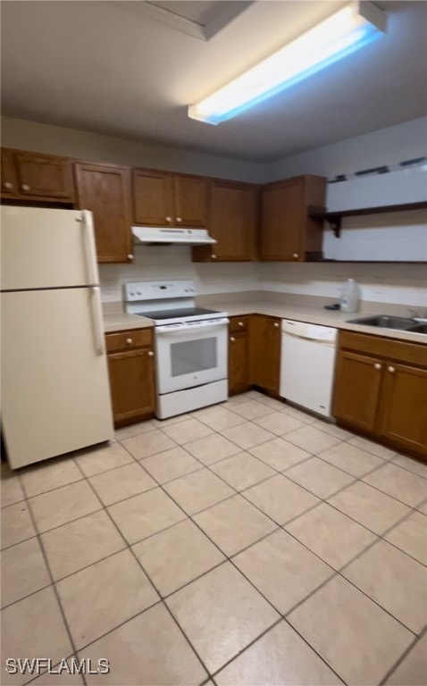 kitchen with white appliances, sink, and light tile patterned floors