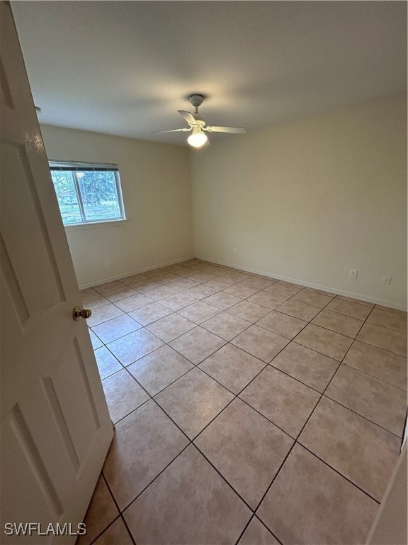 tiled spare room with ceiling fan