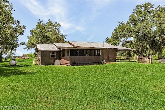 back of house featuring a lawn and an outbuilding