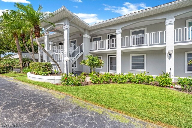 exterior space featuring a balcony and a front lawn