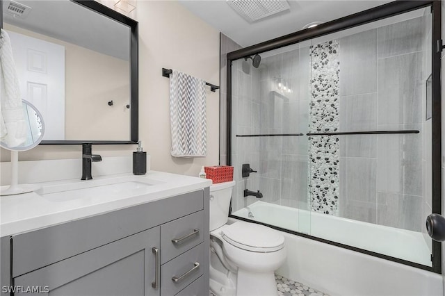 full bathroom with shower / bath combination with glass door, vanity, and toilet