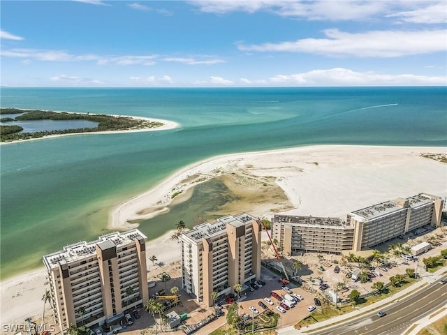 birds eye view of property with a water view and a beach view