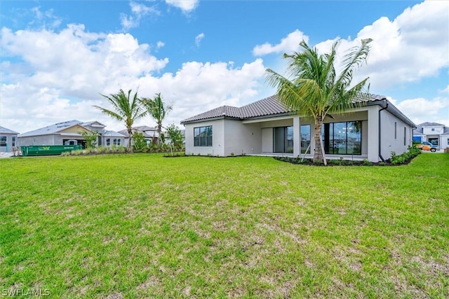 rear view of house featuring a lawn