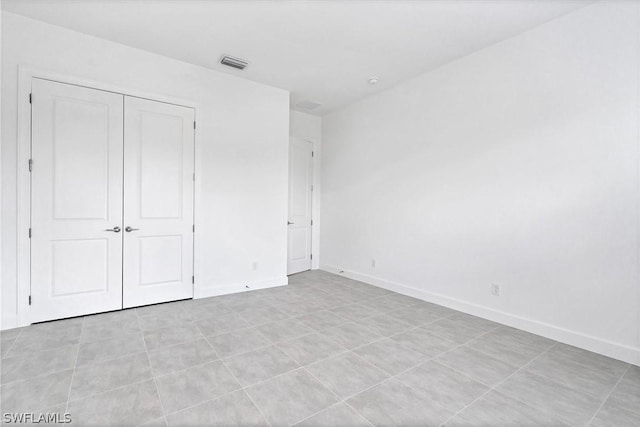 unfurnished bedroom with light tile patterned floors and a closet