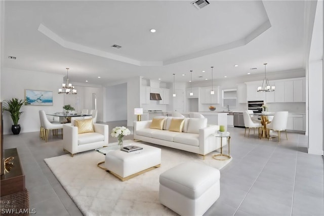 living room featuring a tray ceiling and a chandelier