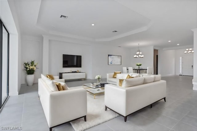 living room featuring a raised ceiling and a notable chandelier