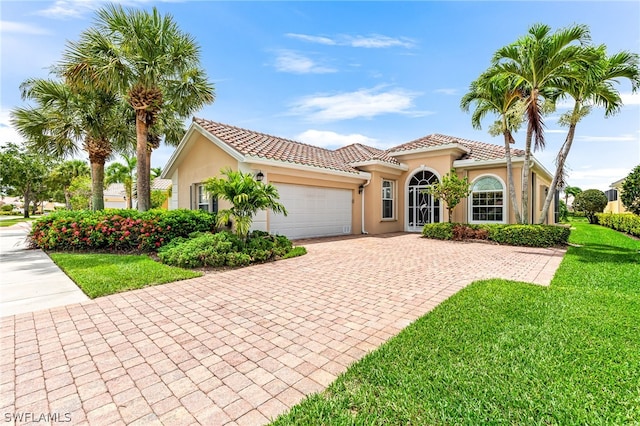 mediterranean / spanish-style home with a garage and a front lawn