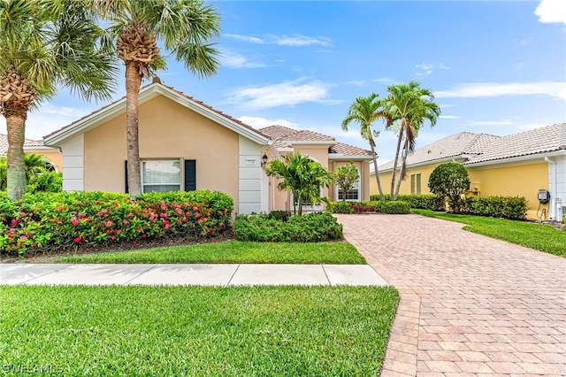 mediterranean / spanish home featuring a front lawn