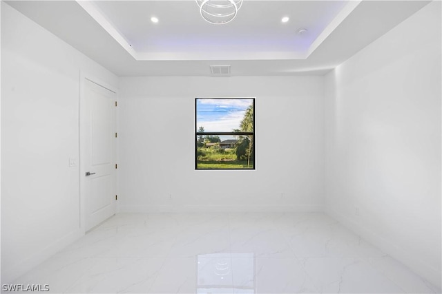 unfurnished room with a raised ceiling