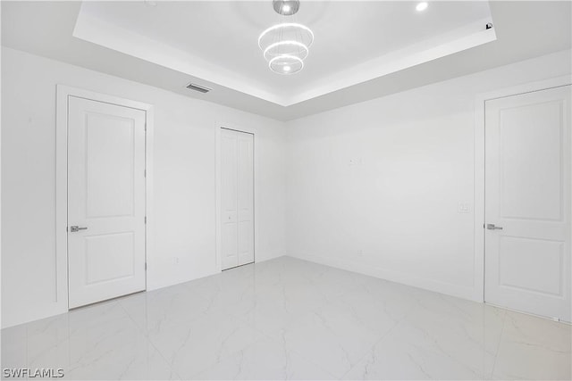 unfurnished bedroom with a raised ceiling