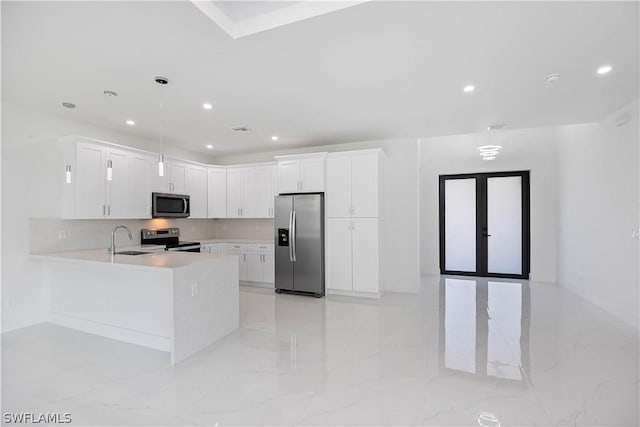 kitchen featuring sink, stainless steel appliances, kitchen peninsula, decorative light fixtures, and white cabinets