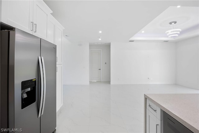 kitchen featuring dishwashing machine, stainless steel fridge, decorative light fixtures, and white cabinetry