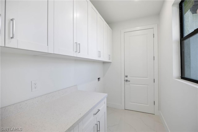 clothes washing area featuring cabinets