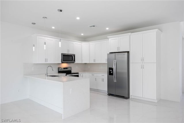 kitchen with kitchen peninsula, white cabinets, pendant lighting, and appliances with stainless steel finishes