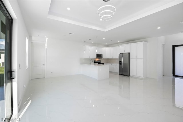 kitchen featuring kitchen peninsula, stainless steel appliances, a tray ceiling, pendant lighting, and white cabinets