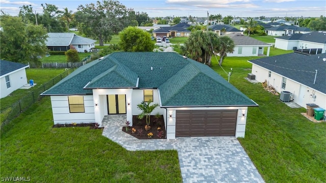 exterior space with a front yard, a garage, and cooling unit