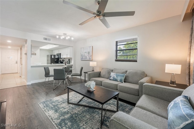 living room featuring wood-type flooring and ceiling fan