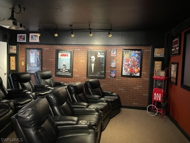 carpeted cinema featuring brick wall and rail lighting