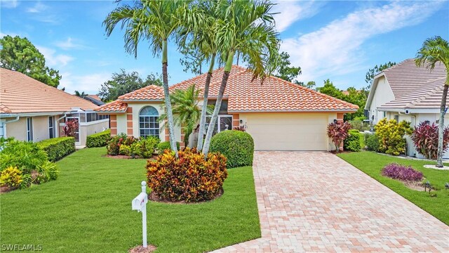 mediterranean / spanish-style home featuring a garage and a front yard