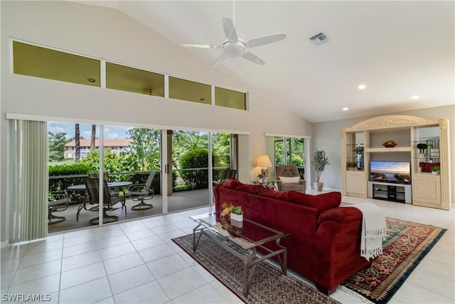 living room with ceiling fan, a wealth of natural light, high vaulted ceiling, and light tile patterned flooring