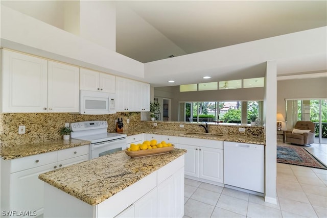 kitchen with sink, white cabinets, light tile patterned floors, light stone counters, and white appliances