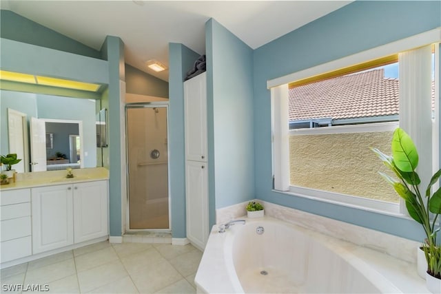 bathroom with tile patterned flooring, vanity, lofted ceiling, and shower with separate bathtub