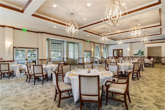 dining space with french doors, a tray ceiling, ornamental molding, and a chandelier