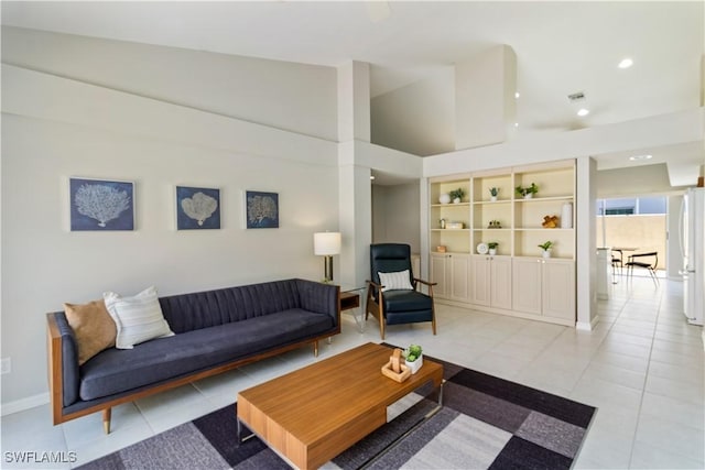 living area with light tile patterned floors, high vaulted ceiling, recessed lighting, and baseboards