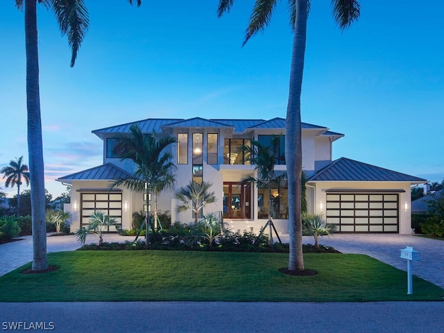 view of front of house featuring a garage and a lawn