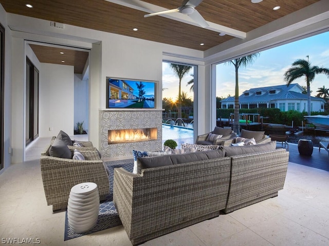 view of patio with an outdoor living space with a fireplace and ceiling fan