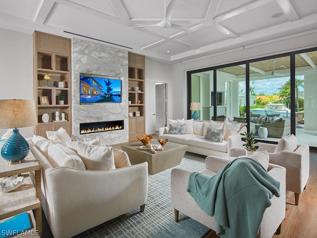 living room with a fireplace, beamed ceiling, wood-type flooring, coffered ceiling, and built in shelves