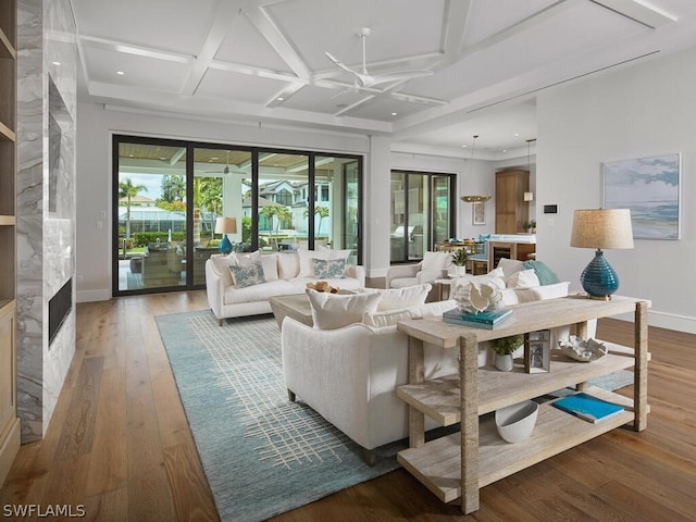 living room featuring beamed ceiling, coffered ceiling, and hardwood / wood-style floors