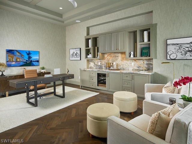 bar with gray cabinets, wine cooler, decorative backsplash, dark parquet flooring, and light stone countertops