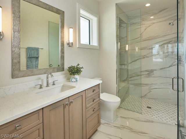 bathroom with vanity, toilet, and a shower with shower door