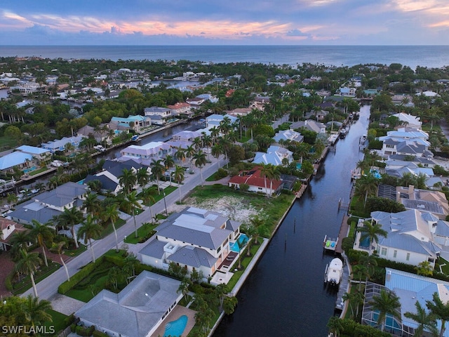 aerial view at dusk featuring a water view