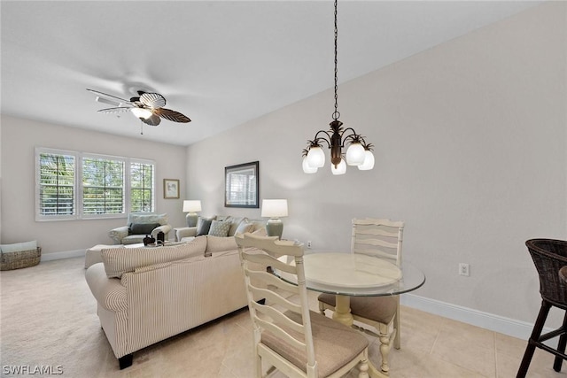 tiled dining room featuring ceiling fan with notable chandelier