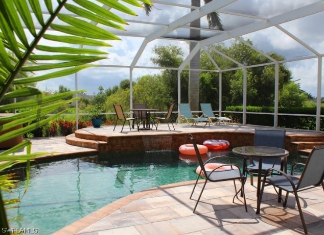 view of swimming pool with a lanai and a patio