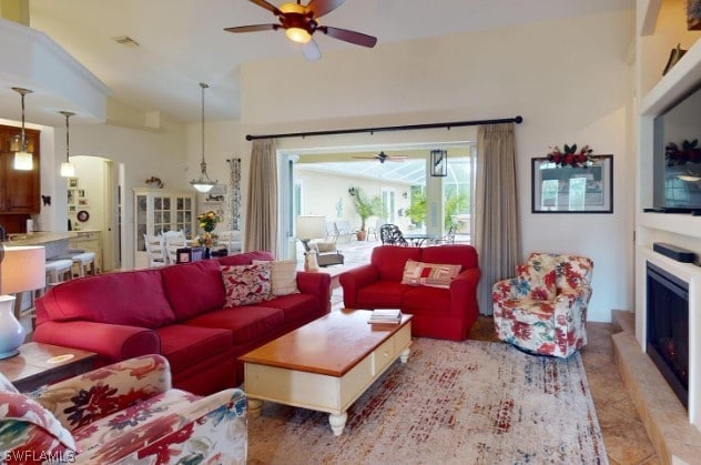 tiled living room featuring high vaulted ceiling and ceiling fan