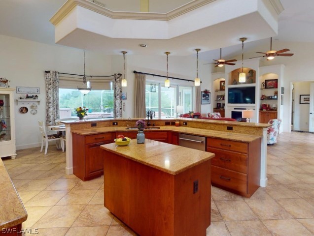 kitchen featuring decorative light fixtures, ceiling fan, and a kitchen island