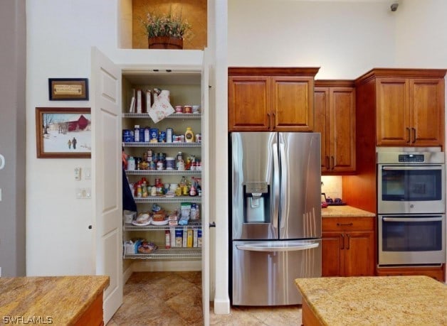 kitchen featuring light tile floors and stainless steel appliances